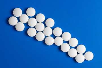 white round pills scattered blue background, chaotically scattered.