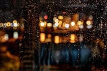 Beautiful Shot Of Water Drops On A Window During A Rainy Night With A Blurred Background