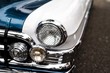 Leinwandbild Motiv Closeup of headlamps of a white and blue retro car