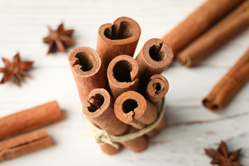 Poster - Cinnamon sticks on white wooden background, space for text and close up