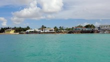 Aerial: Quaint Whitewashed Waterfront Home With People Enjoying The Swimming Pool  - Nassau, Bahamas