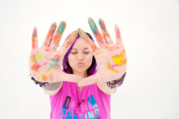 Happy kissing artist woman with colorful paint all over her hands. 