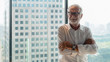 © Mongkolchon - portrait of senior businessman with beard and glasses feeling confident standing in executive room in business building