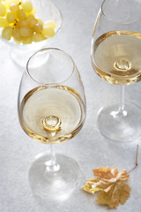 Wall Mural - White wine in a glass and grapes on the table. Light background.