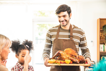 Thanksgiving Celebration Tradition Family Dinner Concept.family having holiday dinner and cutting turkey.Young black adult woman and her daughter happy.