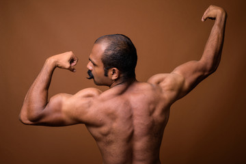 Rear view of muscular Indian man with mustache shirtless