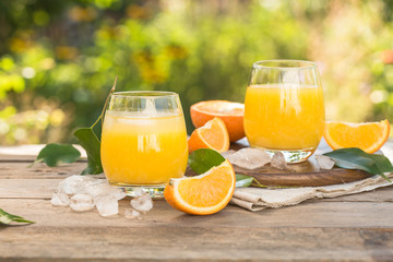 Glass of fresh orange juice,ripe orange fruit and slices on natural .Freshly squeezed orange juice with drinking straw,orange fruit and orange slices.