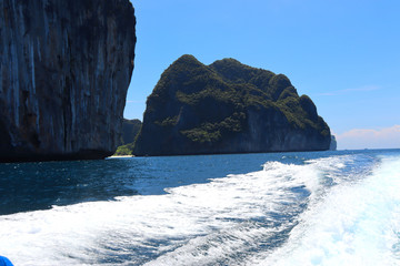 boat ride on the sea, exotic James Bond islands against the blue sea, waves of spray in Thailand