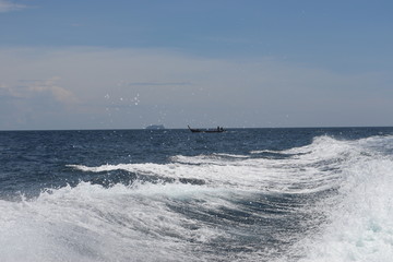 Wall Mural - boat ride on the sea, exotic James Bond islands against the blue sea, waves of spray in Thailand