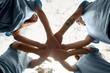 © Viktoriia - Volunteering. Young people volunteers outdoors standing hands together close-up bottom view teamwork