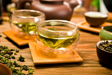 Wall Mural - Chinese tieguanyin tea in a glass cups on wooden background. 