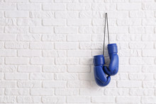 Pair Of Boxing Gloves Hanging On Brick Wall