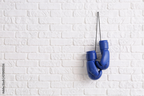 Cuadros en Lienzo Pair of boxing gloves hanging on brick wall