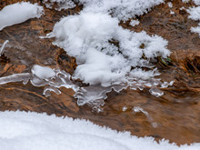 Abstract Picture With Running Water, Snow, Rocks And Ice Formations, Suitable For Winter Background