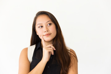 Wall Mural - Pensive student girl touching face with finger. Young Latin woman in casual standing isolated over white background, looking at copy space away. Advertising concept