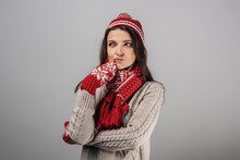 Pensive Woman In Red Knitted Had, Gloves And Scarf Isolated On Grey