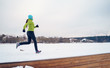 Photo of young athlete girl running in winter park