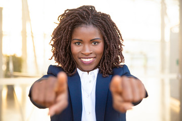 Wall Mural - Happy positive recruit agent pointing fingers at camera, choosing you. Young African American business woman standing and posing outside. Career concept