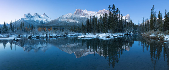Wall Mural - almost nearly perfect reflection of the three sisters peaks in the bow river. near canmore, alberta 
