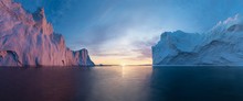 Early Morning Summer Alpenglow Lighting Up Icebergs During Midnight Season. Ilulissat, Greenland. Summer Midnight Sun And Icebergs. Blue Ice In Icefjord. Affected By Climate Change And Global Warming.