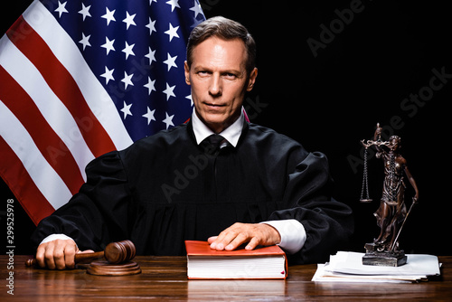 Fotomural judge in judicial robe holding gavel and putting hand on book