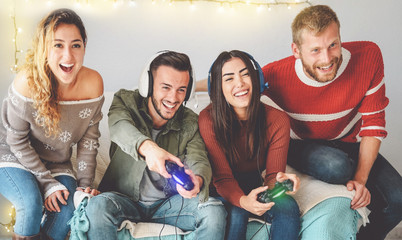 Happy friends playing video games online with headset - Young people having fun with new trendy technologies console gaming - People entertainment and youth millennial generation lifestyle concept