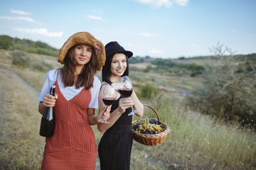 Wall Mural - Two happy girls with two glasses of wine in their hands.