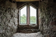 © Nick Beer - Atmospheric view of a medieval building seen from within, looking out an ornate window. The texture and stone work of the surround is clearly evident.