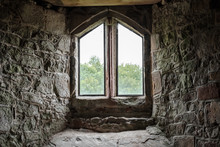 Atmospheric View Of A Medieval Building Seen From Within, Looking Out An Ornate Window. The Texture And Stone Work Of The Surround Is Clearly Evident.
