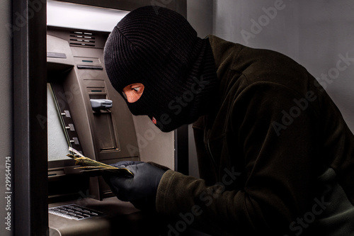 Fotomural thief with crowbar opens the ATM.
