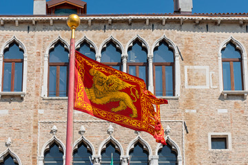 Wall Mural - Venetian Flag in front of traditional building in Venice, Italy.