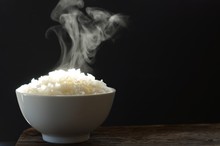 Jasmine Rice In A Bowl. Selective Focus Steaming Hot Cooked Rice In White Bowl On Black Background.
