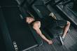 top view of unconscious sportsman lying on treadmill in gym