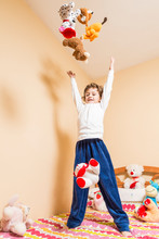 Child Throwing A Lot Of Stuffed Animals In The Air.