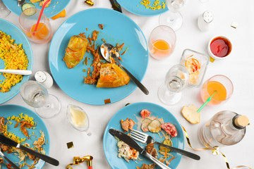 Wall Mural - Flat lay composition with food leftovers on white tablecloth after party