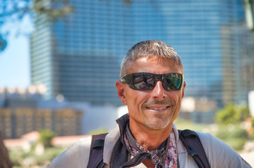 Poster - Happy man with sunglasses visiting big city in the summer.