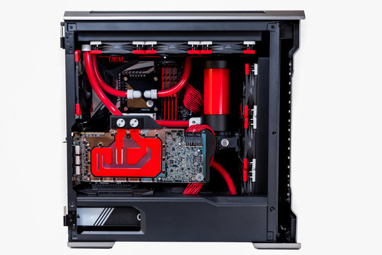 	 Open computer with water cooling system, processor, graphics card, motherboard fan Game console behind white background