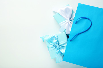 Shopping bag with gift boxes on grey background