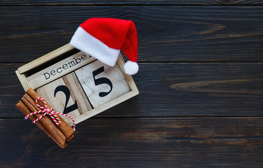 Wooden calendar on the table with 25 of December on it. Holidays and celebration concept, greeting card mockup, festive decoration. Christmas and New Year composition.