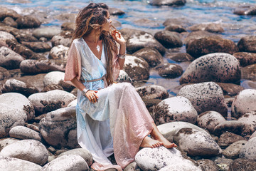 Wall Mural - beautiful young woman in stylish boho dress posing outdoors at sunset