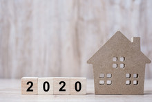 2020 Happy New Year With House Model On Wooden Background. Banking, Real Estate, Investment, Financial, Savings And New Year Resolution Concepts