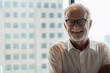 © Mongkolchon - portrait of senior businessman with beard and glasses feeling confident standing in executive room in business building