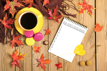 cup with black coffee, yellow lollipops, macaroons, notepad, wooden table with autumn fallen orange leaves Flat lay Top view Mock up Hello september, october, november, sesonal concept Rustic style