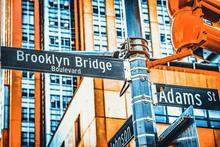 Street Sign (nameplate) Of Brooklyn Bridge And Adams Street And Urban Cityscape Of New York. USA.