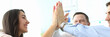 © Тихон Купревич - Portrait of pretty female manager in office performing friendly gesture with joyful coworkers. Businesspeople doing high five. Teamwork concept. Blurred background