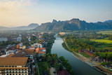 Fototapeta Na ścianę - Aerial view of village Vang Vieng and  Nam Song river , Laos. Southeast Asia. Photo made by drone from above. Bird eye view.
