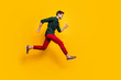 © deagreez - Full size profile side photo of positive cheerful guy jump run fast want hurry to sales discounts wear casual style clothes sneakers isolated over yellow color background