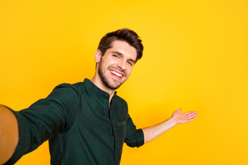 Poster - Close up photo of positive cheerful guy hold hand take selfie invite his blogging followers to perfect rest relax through video call wear casual style outfit isolated over yellow color background