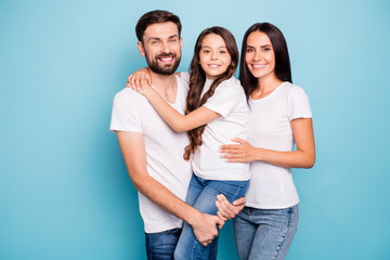 Wall Mural - Portrait of positive cheerful three people mom dad carry kid feel glad wear white stylish t-shirt denim jeans isolated over blue color background