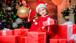 © be free - Child happy excited girl find gifts near christmas tree. Merry christmas. Kid wear santa hat hold wrapped christmas gift box. Santa brought me gifts. Happiness and joy. Happy childhood concept